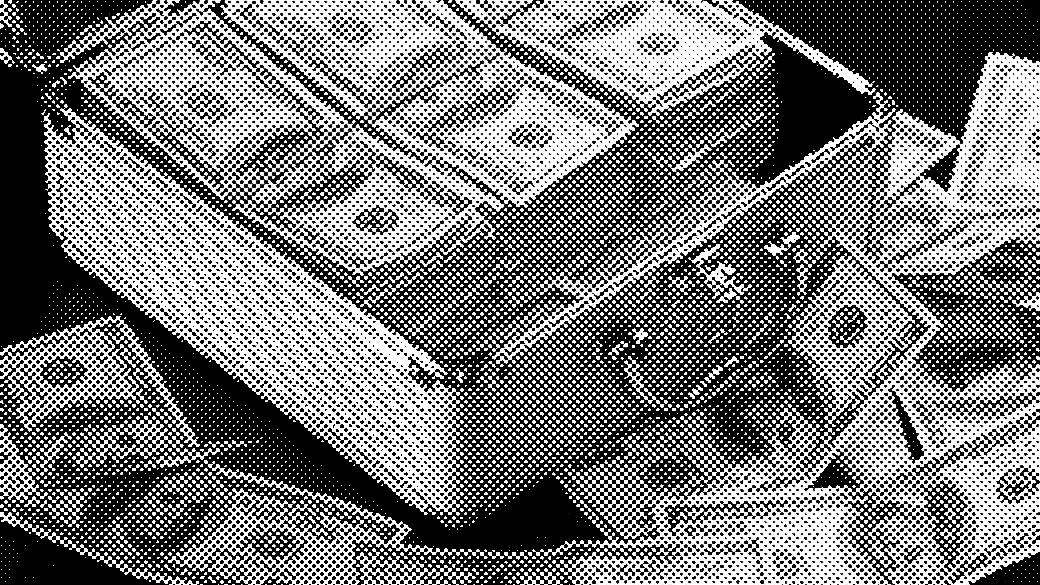Briefcase filled with stacks of U.S. hundred-dollar bills, scattered banknotes around.